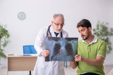 Genç adam yaşlı erkek doktor radyoloğu ziyaret ediyor.