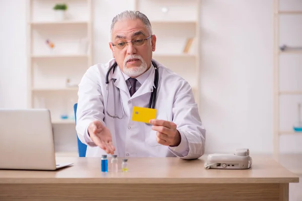 Vieux médecin masculin dans le paiement par carte de crédit et concept de vaccination — Photo