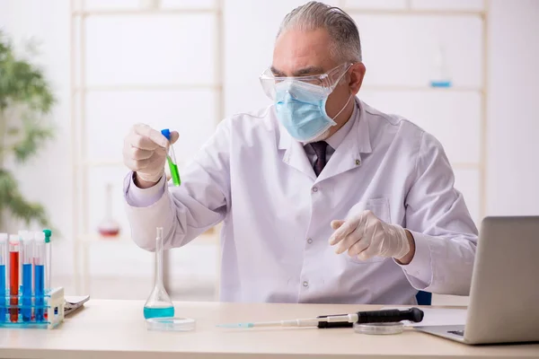 Stary chemik pracujący w laboratorium podczas pandemii — Zdjęcie stockowe