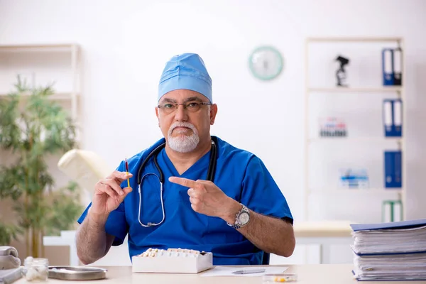 Klinikte çalışan yaşlı erkek doktor. — Stok fotoğraf