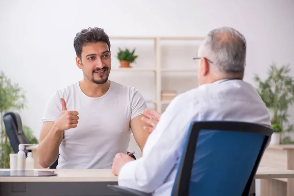 Young male patient visiting old male doctor — Stock Photo, Image