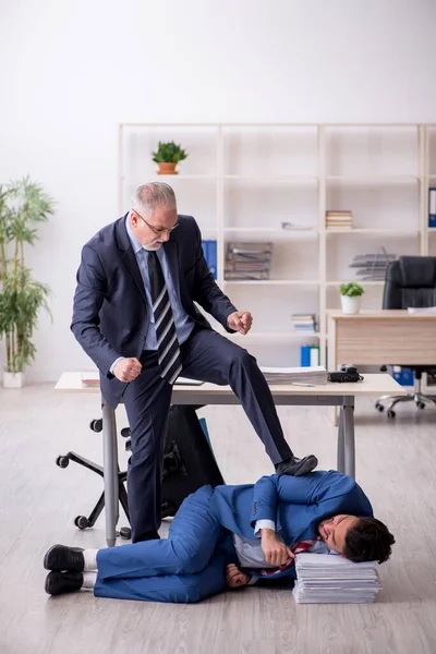 Old boss and young male employee in bullying concept — Stock Photo, Image