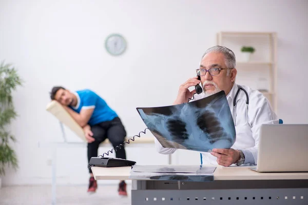 Fiatal férfi beteg látogató idős férfi orvos radiológus — Stock Fotó