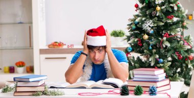 Noel arifesinde kitabı olan genç bir öğrenci.