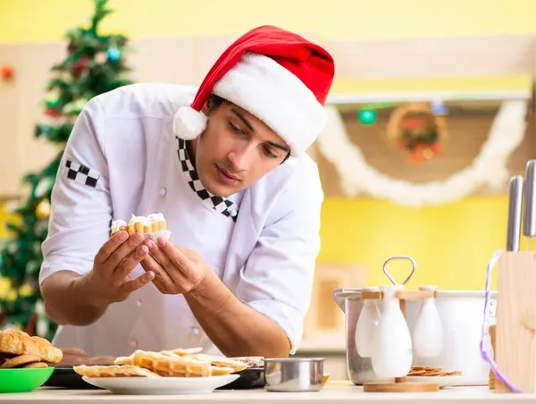 Young chef husband working in kitchen at Christmas eve — Stock Photo, Image
