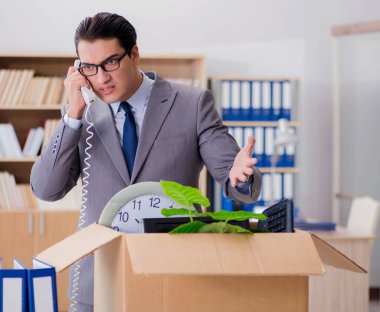 Ofisi kutu ve eşyalarıyla taşıyan bir adam.