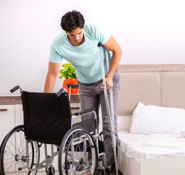 Genç yakışıklı engelli adam evde iyileşiyor.