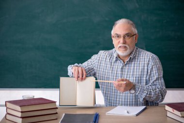 Sınıftaki yaşlı erkek öğretmen.