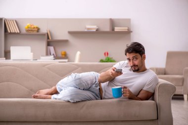 Genç erkek öğrenci salgın sırasında evde oturuyor.