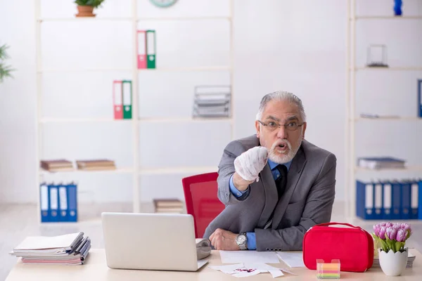Old male employee cutting his hand in the office — Stock Photo, Image