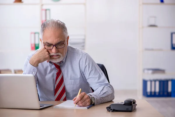 Ancien employé masculin travaillant dans le bureau — Photo