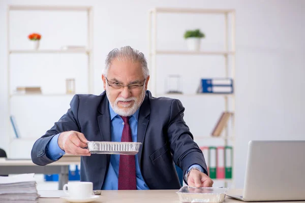 Ancien employé masculin prenant le petit déjeuner dans le bureau — Photo