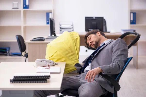 Ung manlig anställd som tar hand om nyfödda på arbetsplatsen — Stockfoto