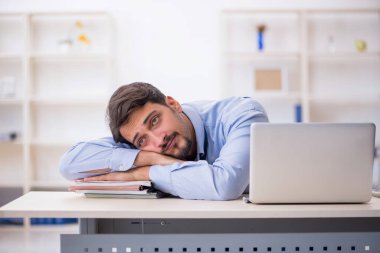 Ofiste çalışan genç bir erkek.