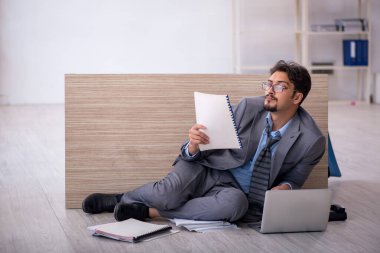 Genç erkek çalışan ofiste fazla mesai yapıyor.