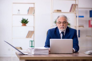 Ofiste çalışan yaşlı bir erkek.