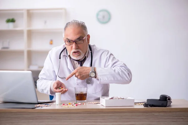 Old male doctor working at the hospital — Stock Photo, Image