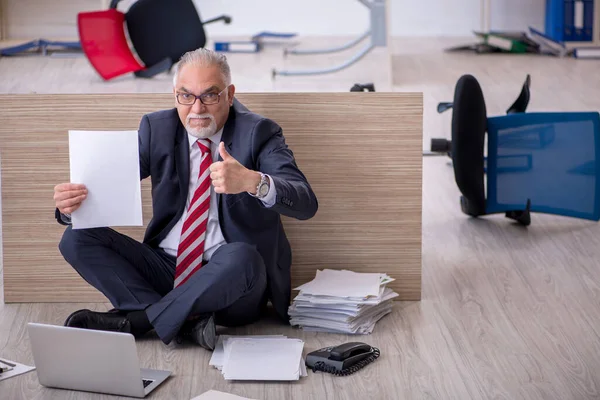 Oude mannelijke werknemer die overuren maakt op kantoor — Stockfoto