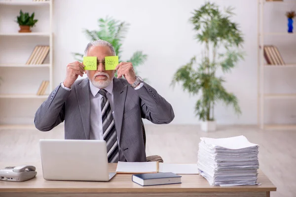 Velho empregado masculino e muito trabalho no escritório — Fotografia de Stock