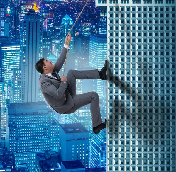 Businessman in challenge concept climbing skyscraper — Stock Photo, Image