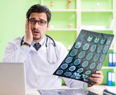 Doktor radyoloji uzmanı hastanede röntgen taramasına bakıyor.