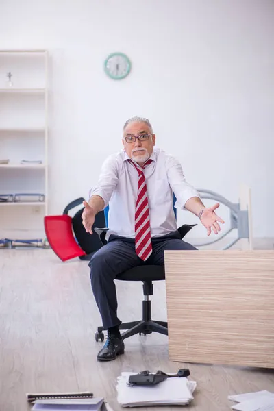 Oude mannelijke werknemer die overuren maakt op kantoor — Stockfoto