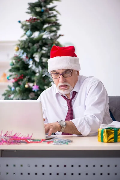 Aged male employee celebrating Christmas at workplace — Stock Photo, Image
