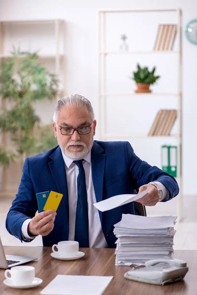 Stary pracownik posiadający kartę kredytową w biurze — Zdjęcie stockowe