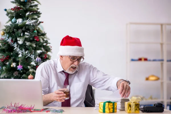 Alderen mandlige medarbejder fejrer jul på arbejdspladsen - Stock-foto