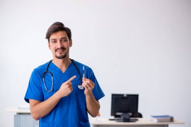 Klinikte çalışan genç erkek doktor.
