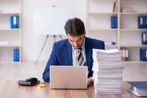 Joven empleado masculino descontento con el trabajo excesivo en la oficina — Foto de Stock