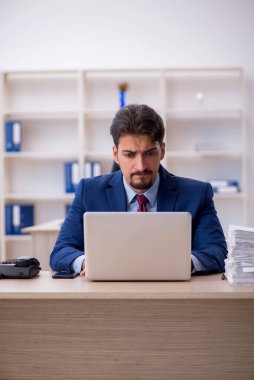 Genç işadamı ve ofiste çok fazla iş var.