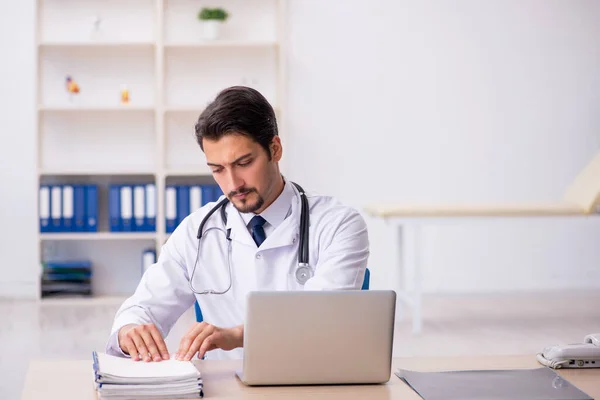 Jonge mannelijke arts werkzaam in de kliniek — Stockfoto