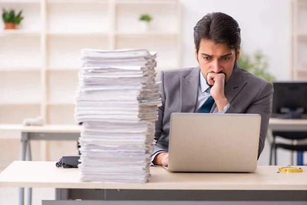 Giovane dipendente maschio infelice con un lavoro eccessivo in ufficio — Foto Stock