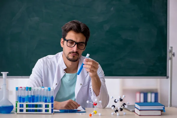 Jonge mannelijke chemicus voor schoolbord — Stockfoto