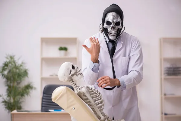 Врач-дьявол осматривает скелет пациента — стоковое фото