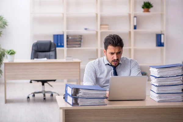 Jeune employé masculin et trop de travail au bureau — Photo