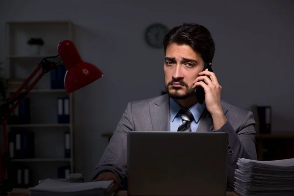 Jovem empregado do sexo masculino que trabalha até tarde no escritório — Fotografia de Stock