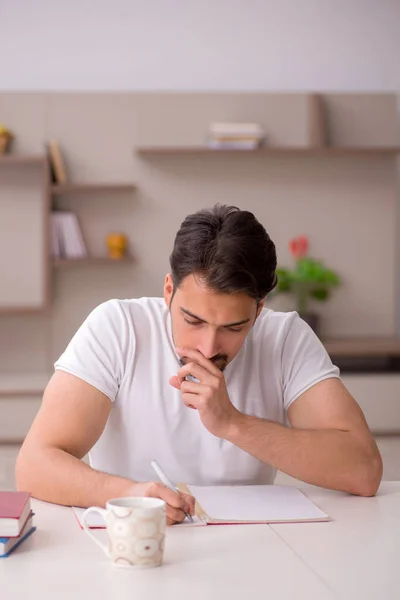 Joven estudiante masculino estudiando en casa durante una pandemia — Foto de Stock