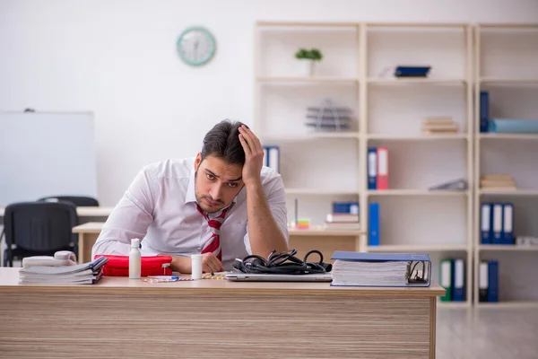 Giovane dipendente maschile che soffre sul posto di lavoro — Foto Stock