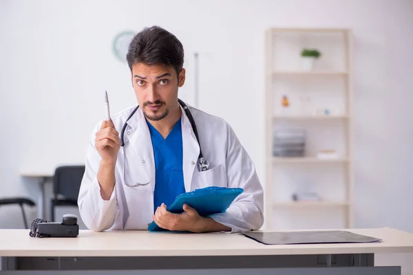 Mladý mužský lékař pracující na klinice — Stock fotografie