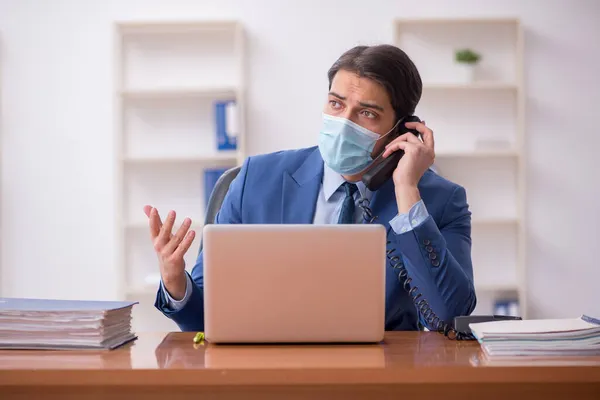 Молодой бизнесмен работает в офисе во время пандемии — стоковое фото