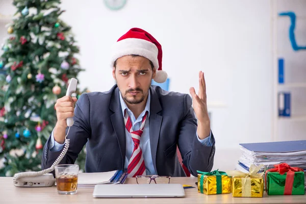 Young male employee celebrating Christmas at workplace — Stock Photo, Image