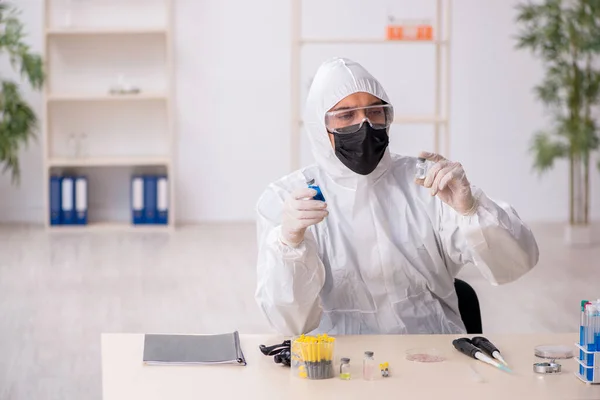 Jeune chimiste masculin travaillant au laboratoire pendant la pandémie — Photo