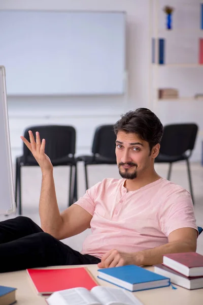 Ung manlig student förbereder sig för tentor i klassrummet — Stockfoto