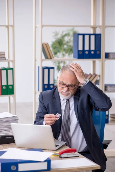 Old male employee feeling bad at workplace — Stock Photo, Image