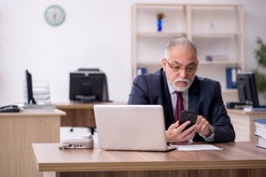 Ofiste çalışan yaşlı bir erkek.