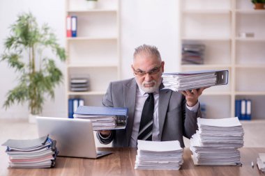 Ofiste çalışan yaşlı bir erkek.