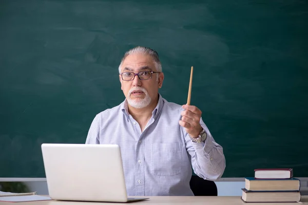Oude mannelijke leraar voor het groene bord — Stockfoto