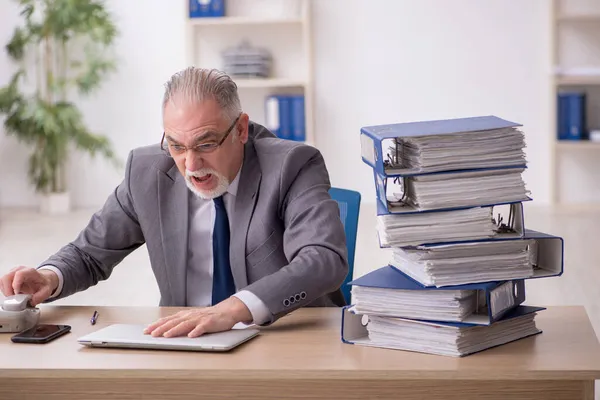 Vieil employé masculin mécontent du travail excessif au bureau — Photo